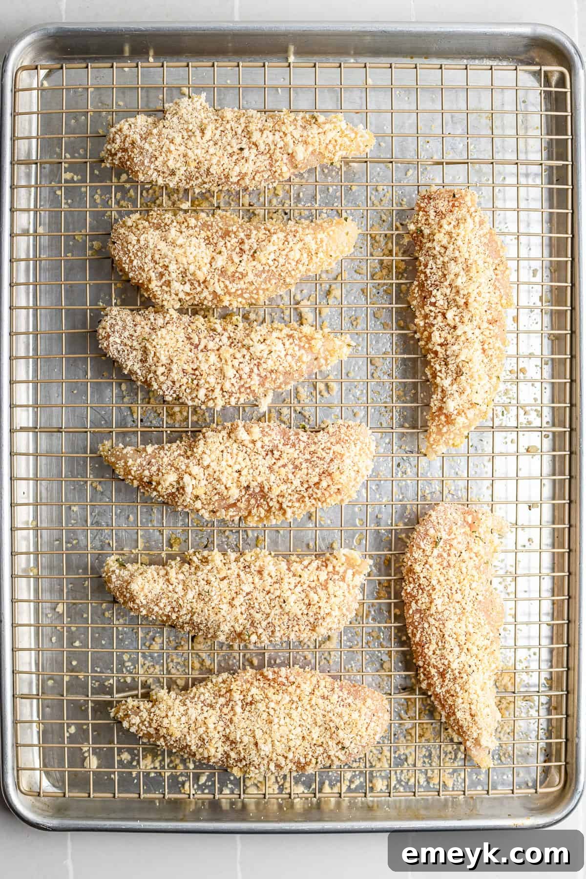Perfectly Crispy Baked Chicken Tenders 6 Step 3 – breaded chicken tenders arranged on wire rack ready for oven.