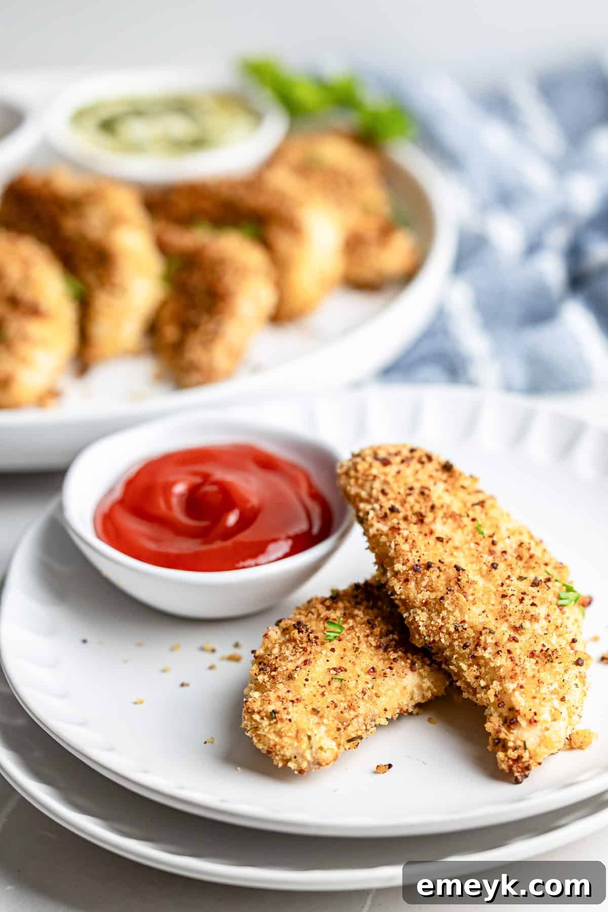 Perfectly Crispy Baked Chicken Tenders 9 Plate of baked chicken tenders with dipping sauce, ready to eat.