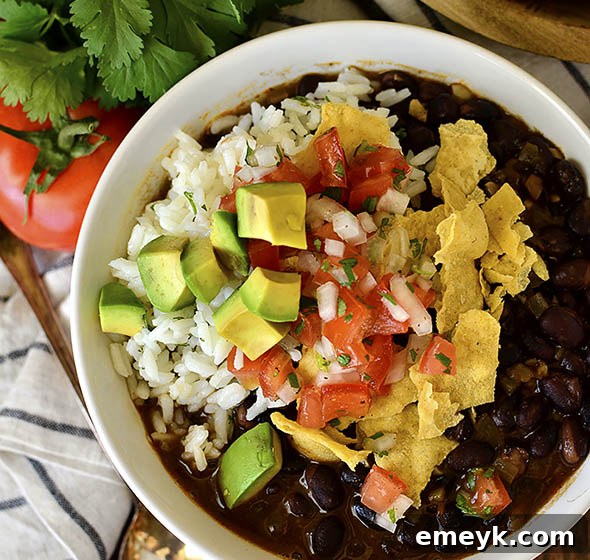 Hearty Black Bean Soup from Iowa Girl Eats topped with sour cream and cilantro