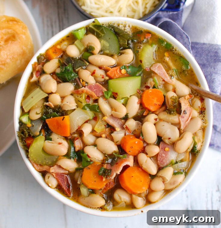 A warm bowl of Tuscan White Bean Soup garnished with fresh rosemary