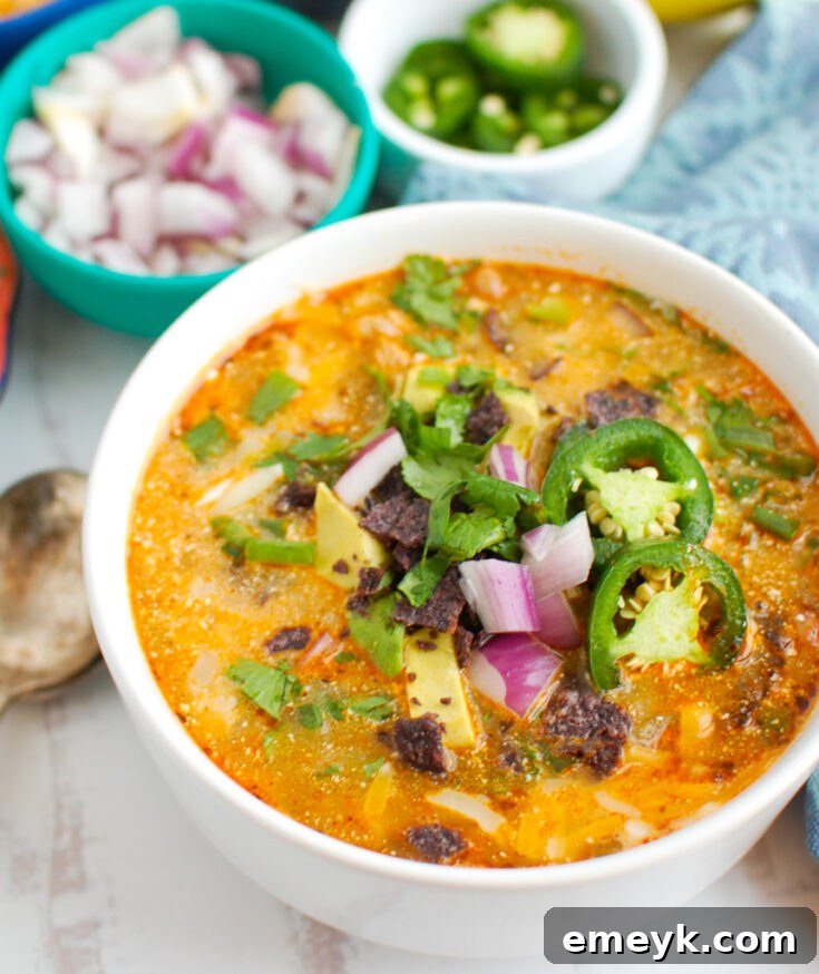 A bowl of creamy Instant Pot White Chicken Chili topped with avocado and sour cream