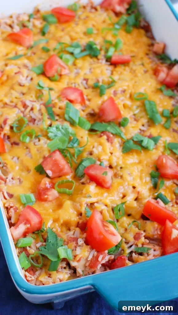 Mexican Chicken Casserole baking in a ceramic dish, with melted cheese on top.