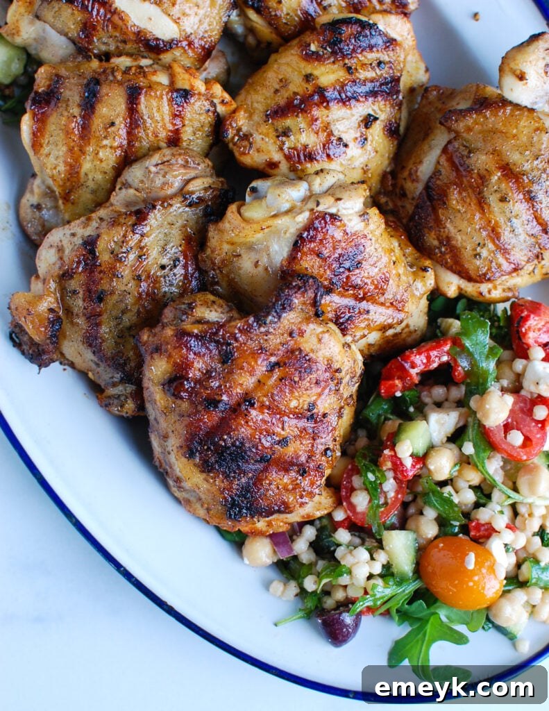 Mediterranean Grilled Chicken Thighs 23 Grilled Greek Chicken Thighs on platter, garnished with fresh herbs