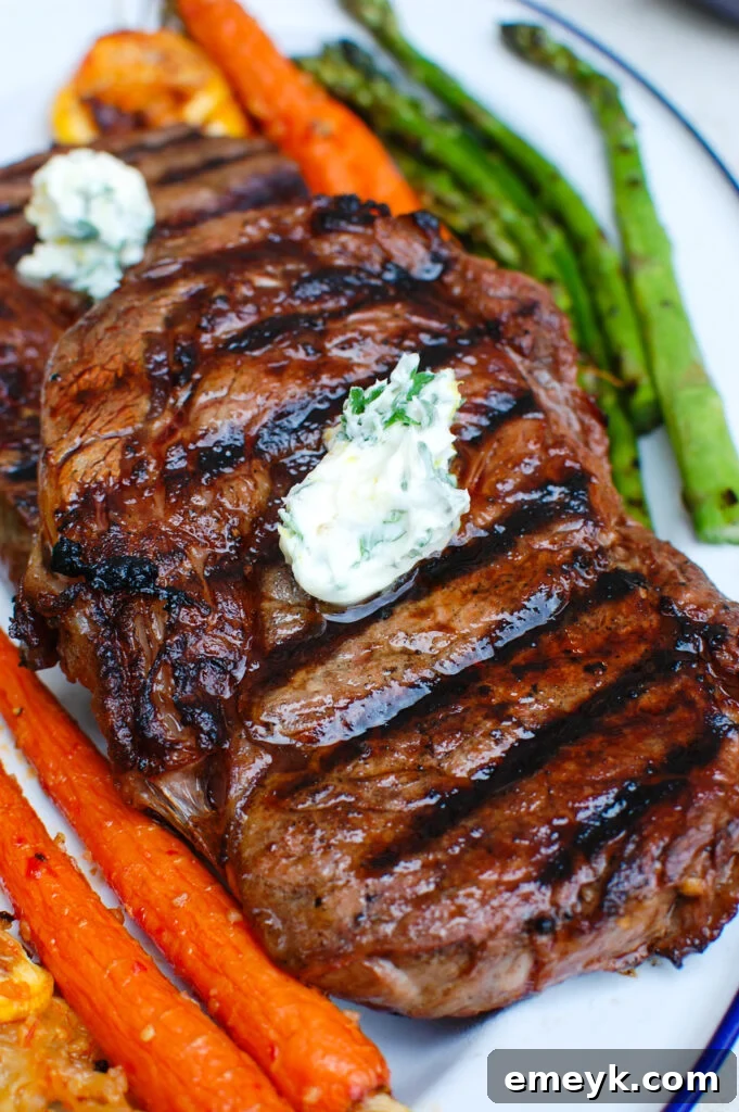 Lemon Garlic Butter Grilled Ribeye steak served on a white plate with fresh herbs