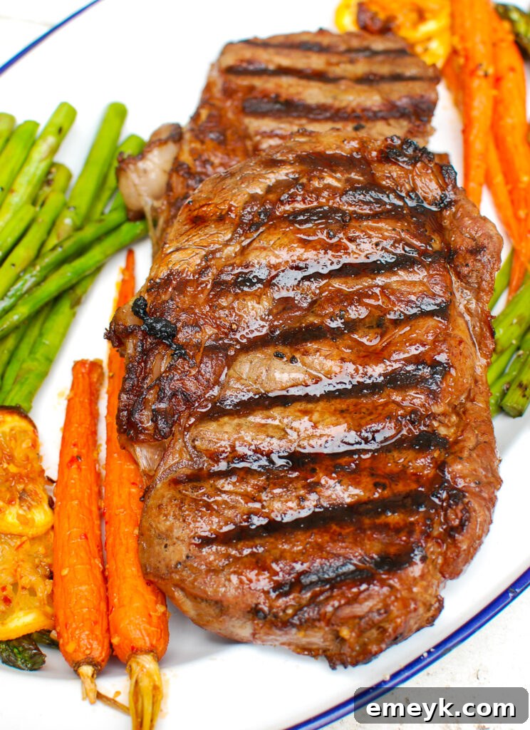 Grilled Lemon Garlic Butter Ribeye steak on a wooden cutting board with a sprinkle of salt