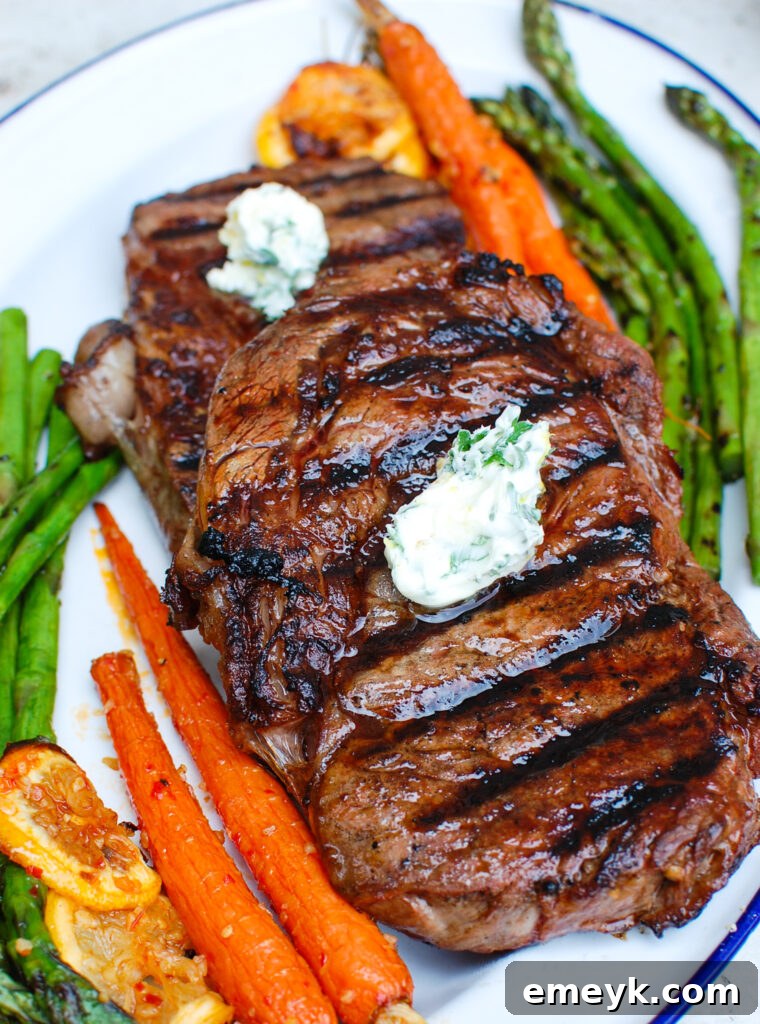 Lemon Garlic Butter Grilled Ribeye topped with melted compound butter and fresh herbs.