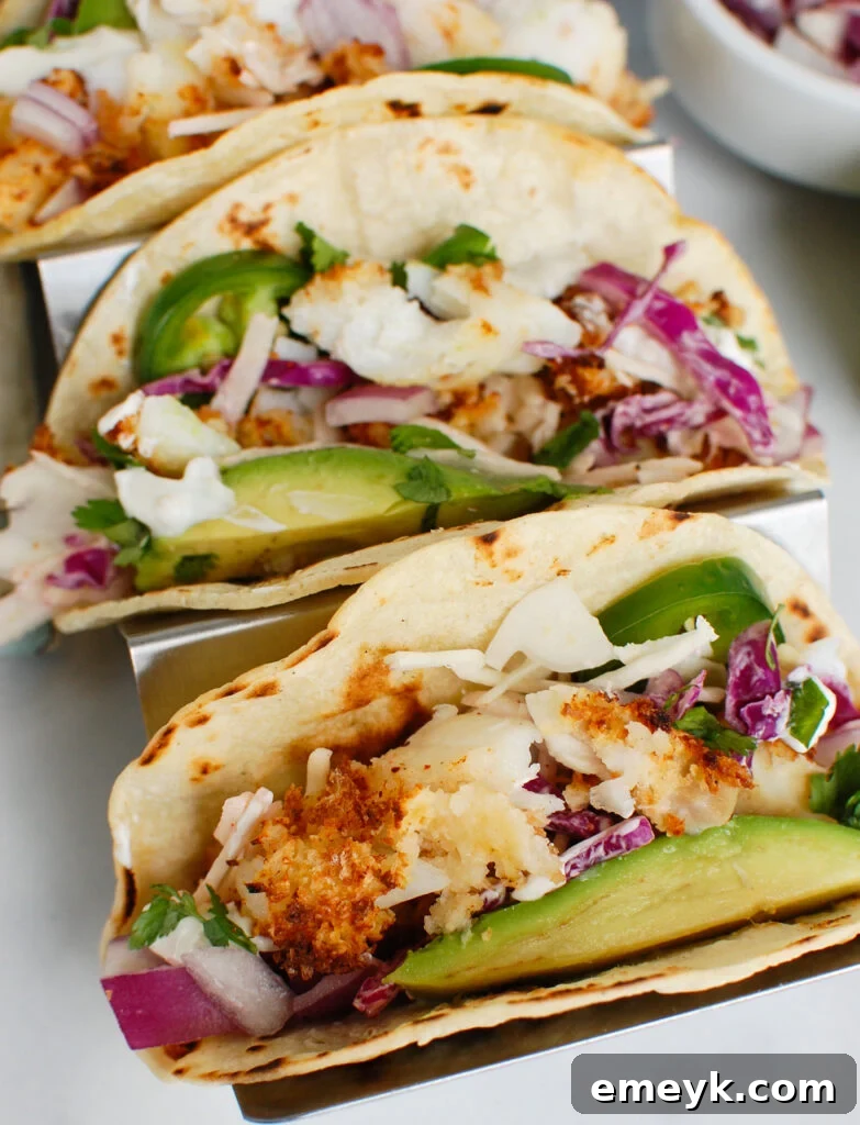 Easy Cod Fish Tacos arranged in a silver tray with fresh toppings
