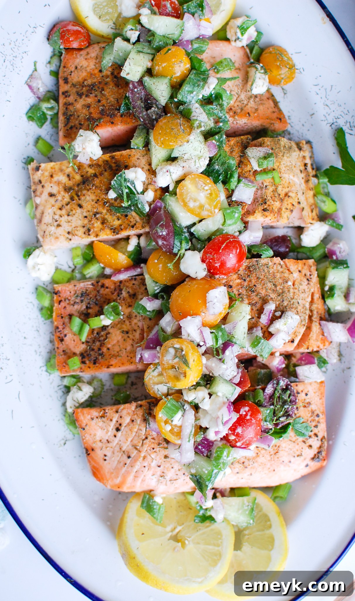 Sundrenched Mediterranean Salmon Bake 7 A large, elegant platter presenting perfectly cooked Mediterranean salmon, generously garnished with fresh and colorful vegetables, olives, and herbs.