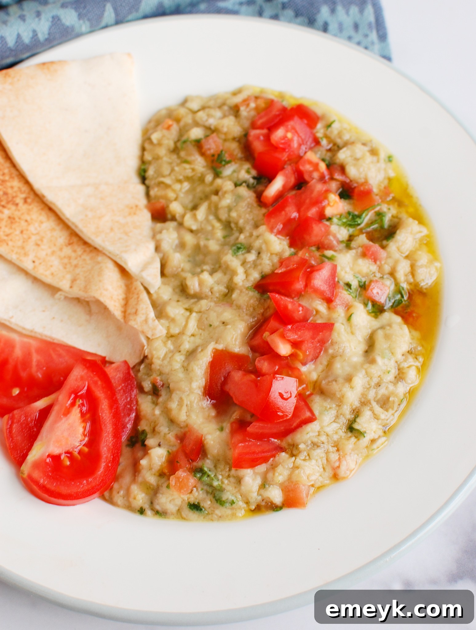 Another view of Ful Medames artfully topped with fresh diced tomatoes, emphasizing its inviting and colorful presentation.