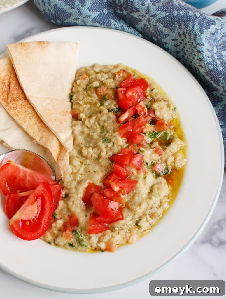 A bowl of creamy Ful Medames, garnished with fresh toppings and ready for serving in a rustic setting.