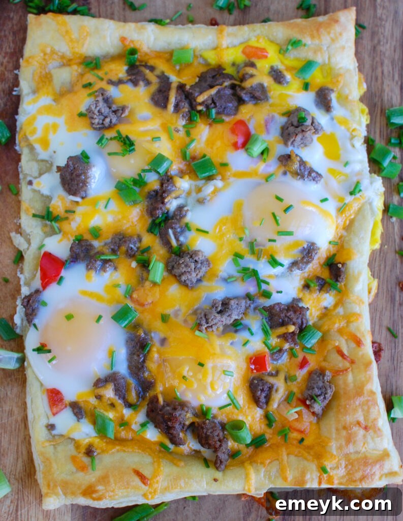 A beautifully baked and complete Turkey Sausage and Egg Puff Pastry Pizza, glistening with melted cheese and ready to be carved.