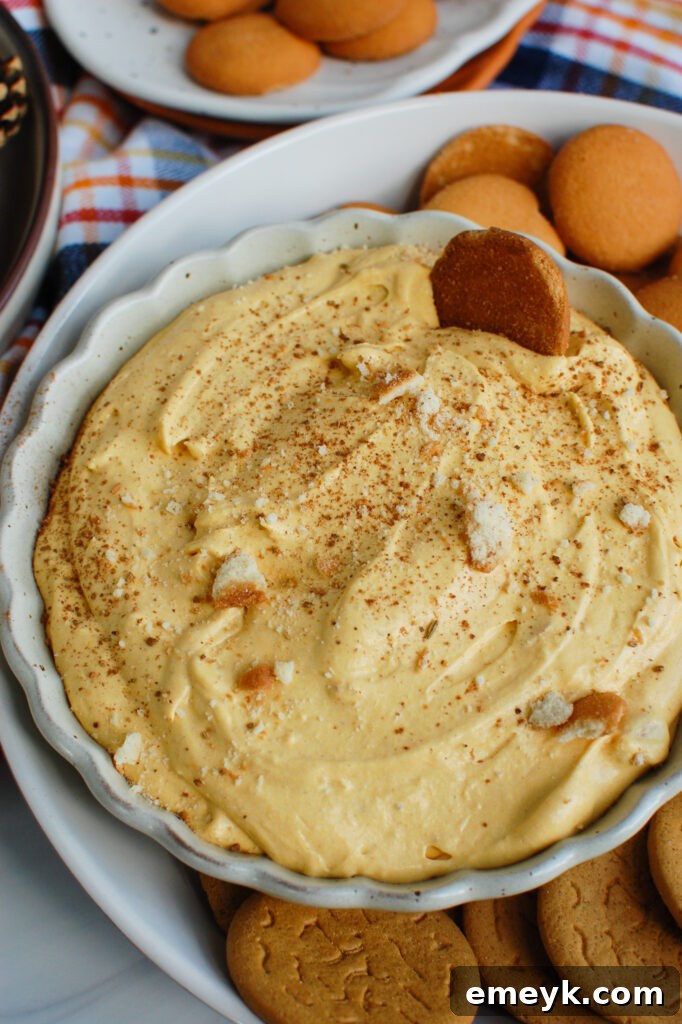 Delightful Pumpkin Dip in a rustic white bowl, garnished with crushed vanilla wafers, ready for fall entertaining