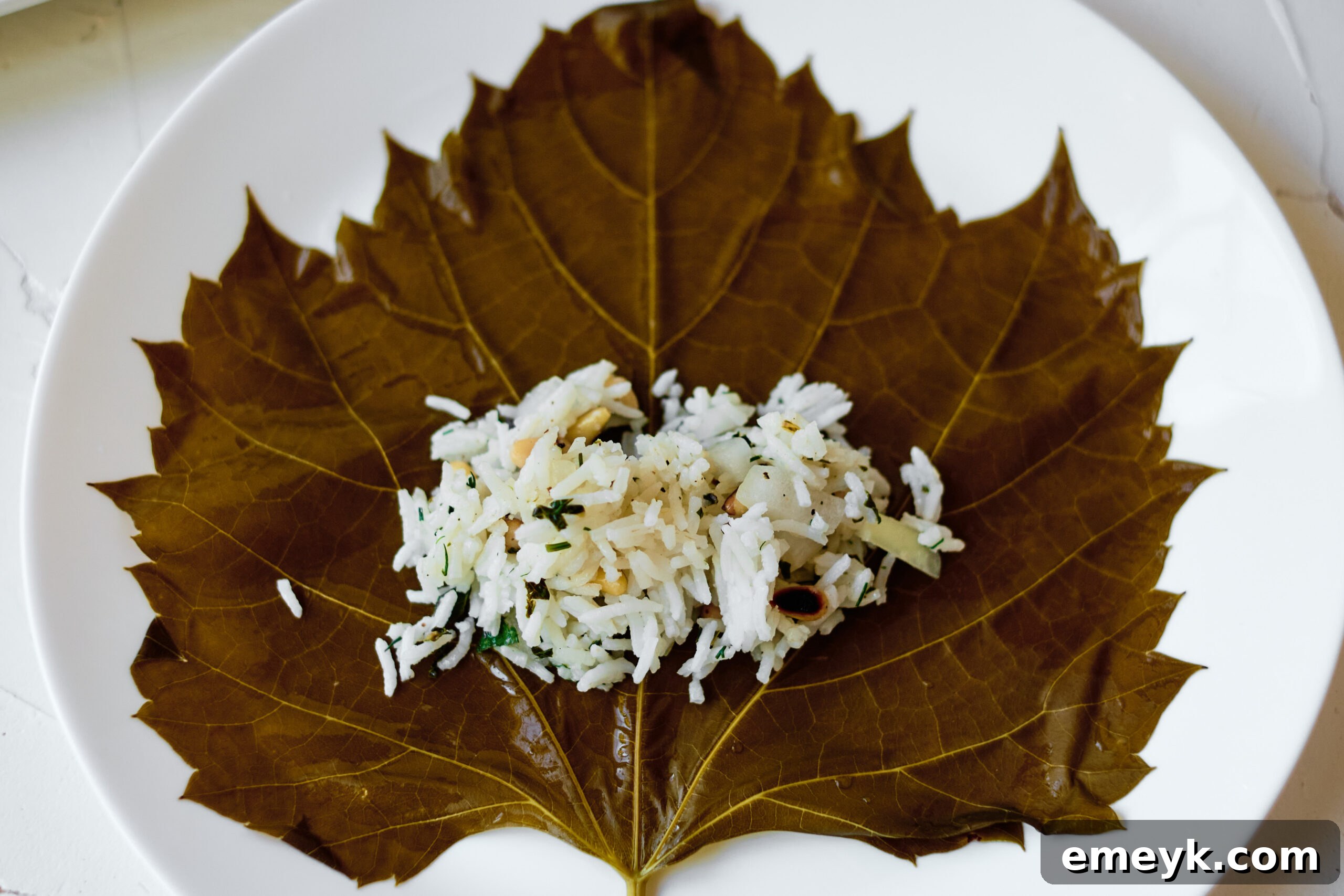 Effortless Homemade Dolma 4 The rice, pine nuts, and herb filling mixture for stuffed grape leaves, prepared in a bowl.