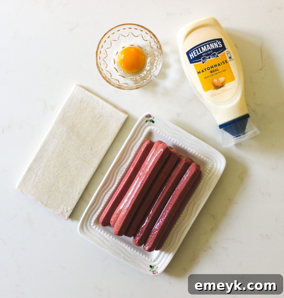 Pharaoh Franks 4 The three main ingredients for Mummy Hot Dogs: a box of puff pastry, a pack of hot dogs, and a small bowl of egg wash.