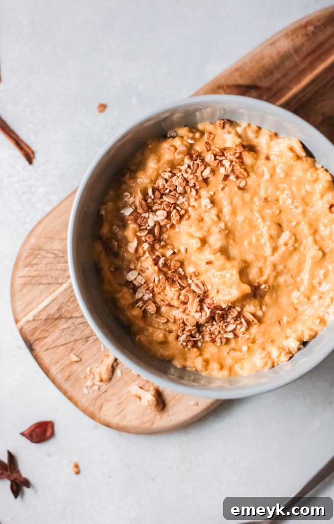 Easy Pumpkin Oatmeal in blue bowl, garnished with pumpkin seeds and a swirl of maple syrup, perfect for a cozy fall breakfast.