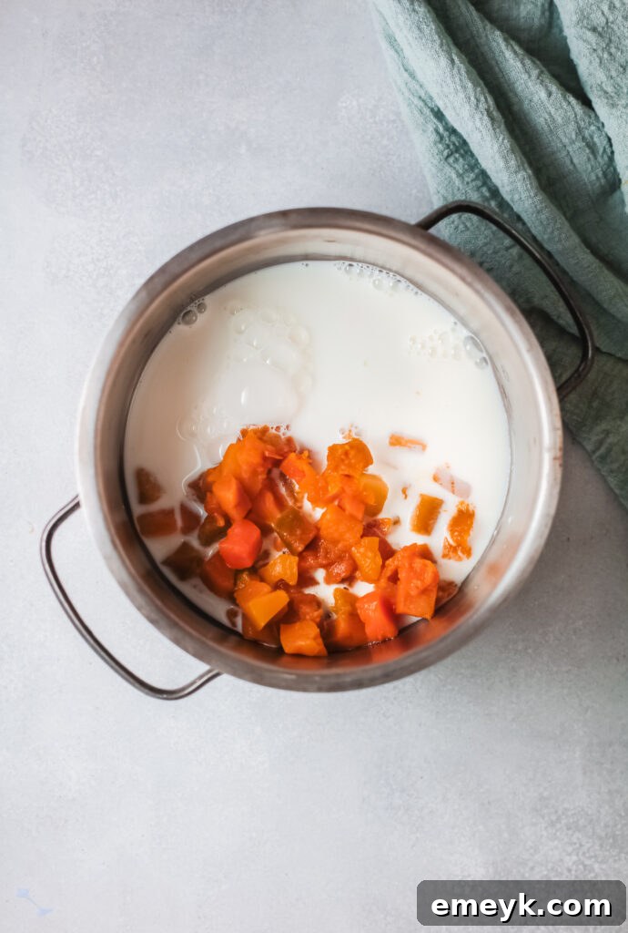 Close-up shot of pumpkin and milk simmering in a saucepan, the initial step for making creamy pumpkin oatmeal.