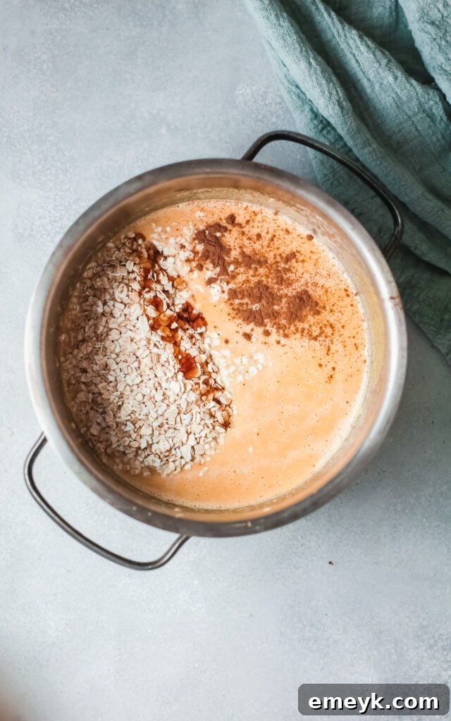 Pumpkin Oatmeal cooking in a pot on the stovetop, showing the thickening process, prior to serving.