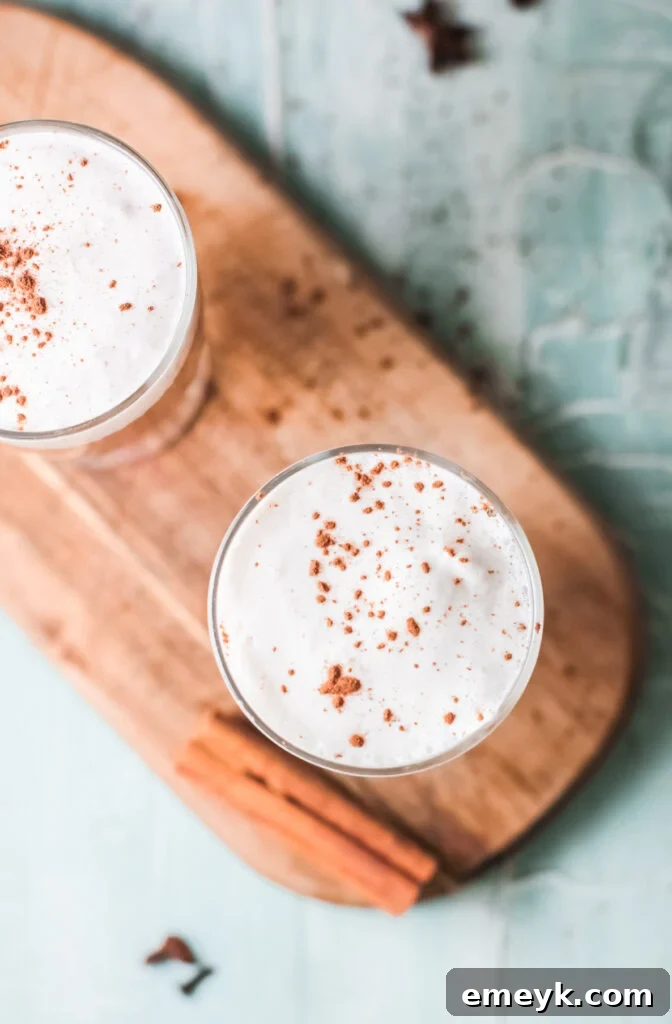 Instant Pot Spiced Chai Latte 4 Overhead shot of an Instant Pot Chai Tea Latte, with a swirl of cinnamon on top of the foam, set against a dark background.