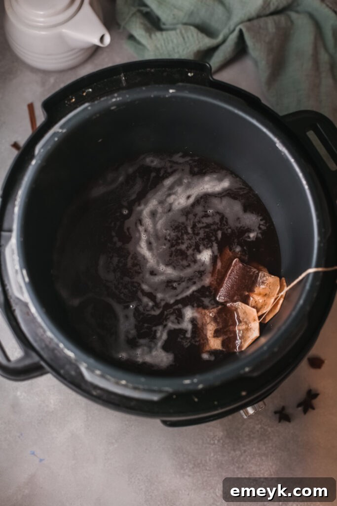 Instant Pot Spiced Chai Latte 6 Inside an Instant Pot, hot tea is steeping with tea bags, ready for the next step of adding spices.