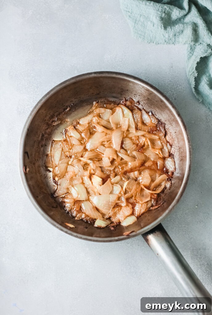 Gnocchi simmering in a savory broth with caramelized onions and wine reduction in a large pot.