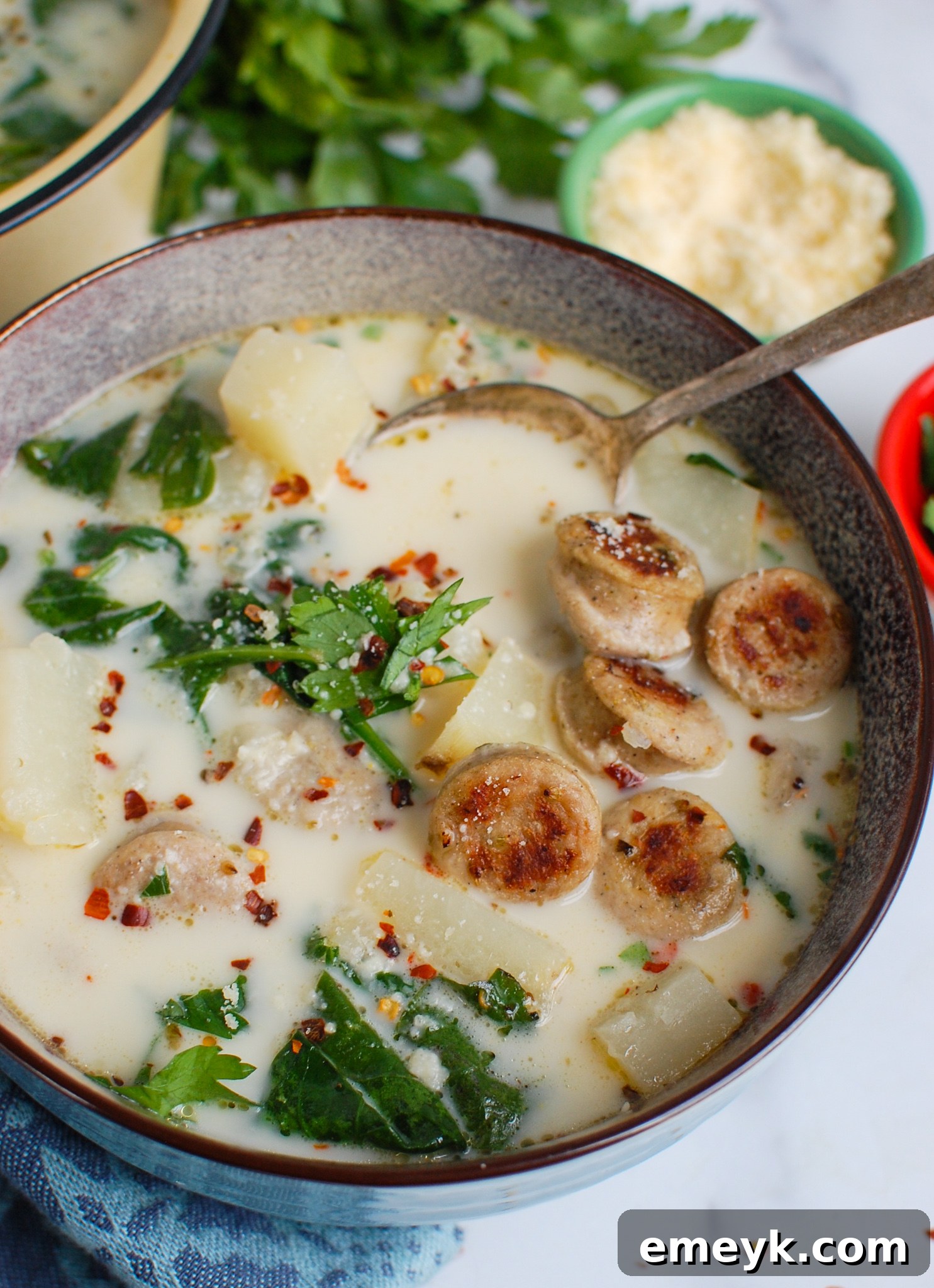 Hearty Slow Cooker Zuppa Toscana 2 Slow Cooker Zuppa Toscana with a spoon, showing creamy texture.