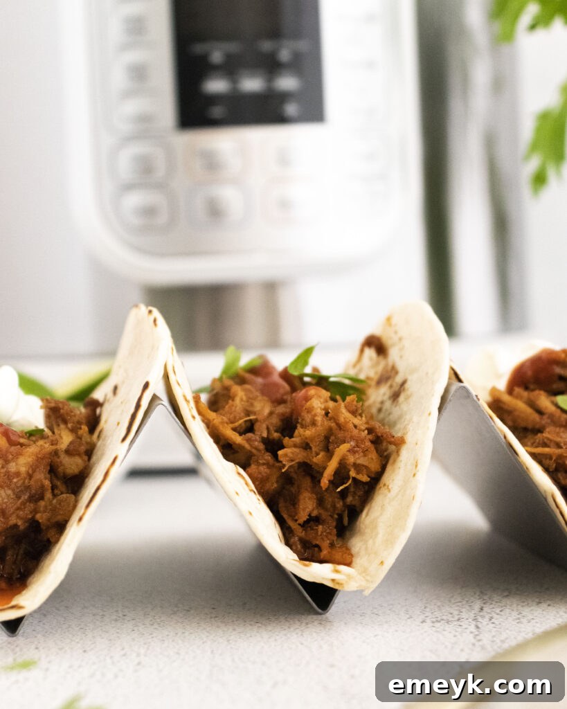 Instant Pot Carnitas tacos arranged in a taco holder