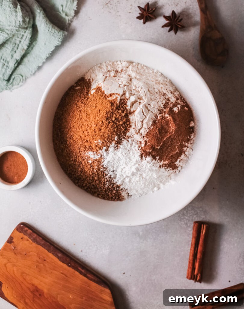 Dry ingredients for Air Fryer Donut Holes: flour, brown sugar, baking powder, pumpkin pie spice, and cinnamon in a bowl.