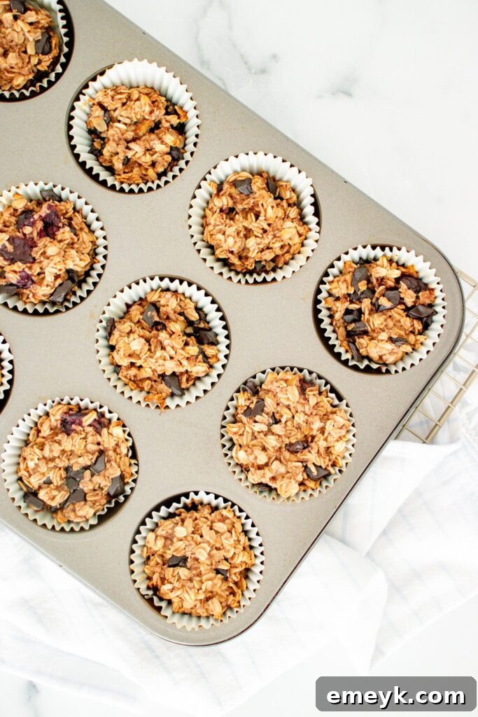 Wholesome Banana Oat Muffins 3 Freshly baked Banana Oatmeal Muffins cooling in a muffin tin, showcasing their golden-brown tops.