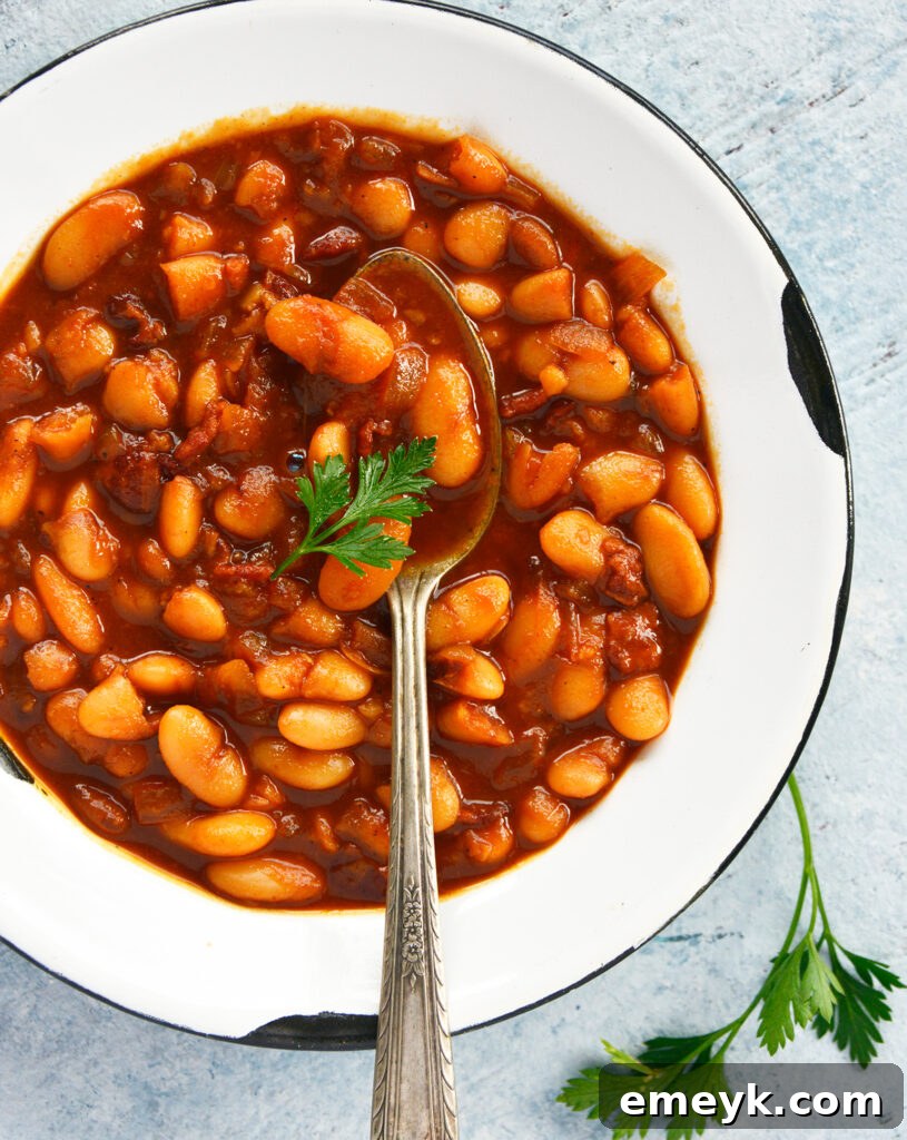 Easy Bacon Baked Beans served with a spoon, highlighting the rich texture.