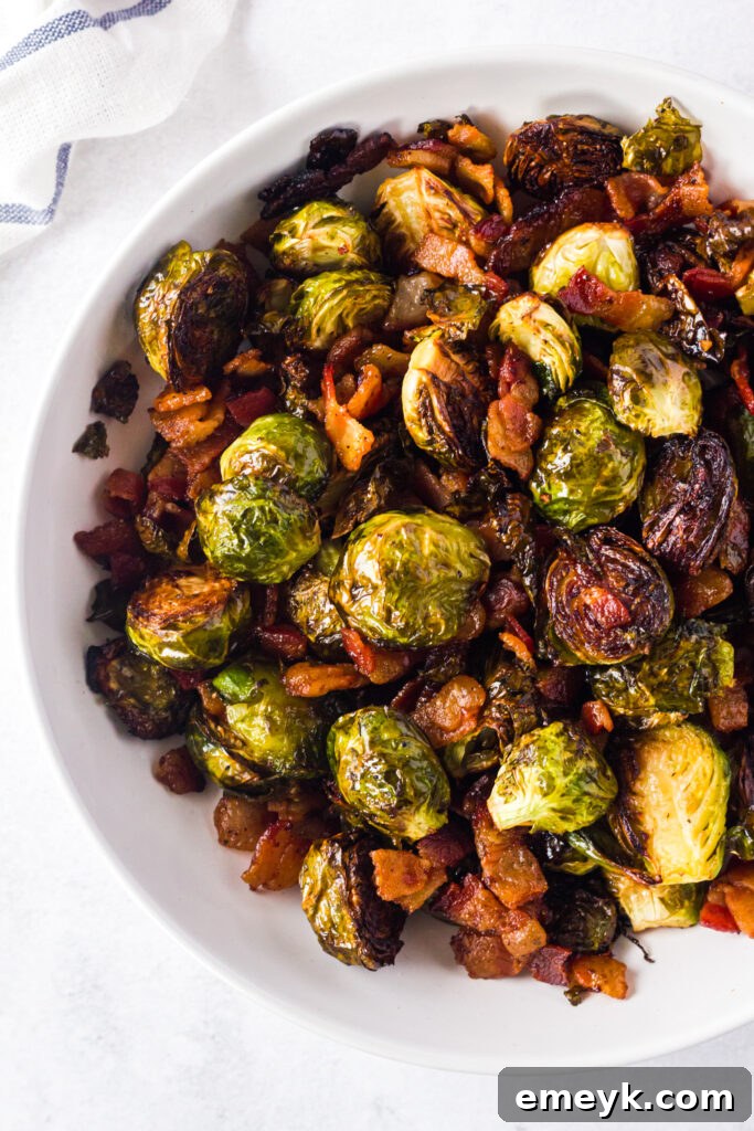 A white bowl filled with glistening roasted Brussels sprouts and crispy bacon, ready to be served as a hearty side dish.