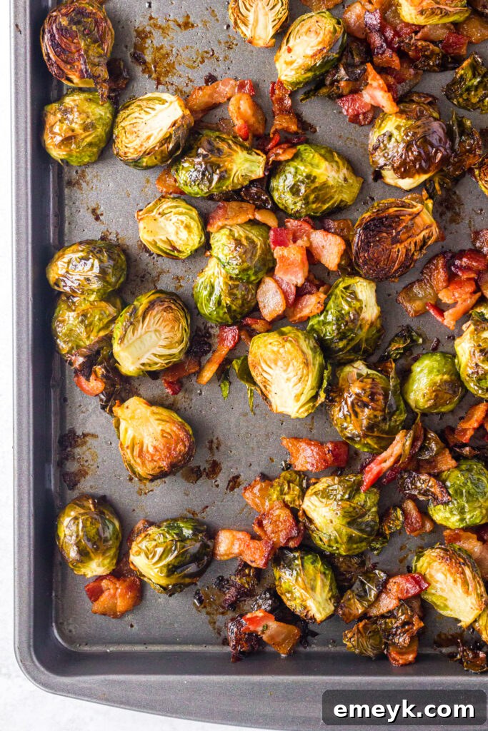 Roasted Brussels Sprouts with Bacon displayed on a baking tray, showcasing the delicious golden-brown caramelization and crispy bacon bits.