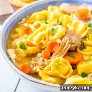 A beautifully presented bowl of Slow Cooker Chicken Tortellini Soup.