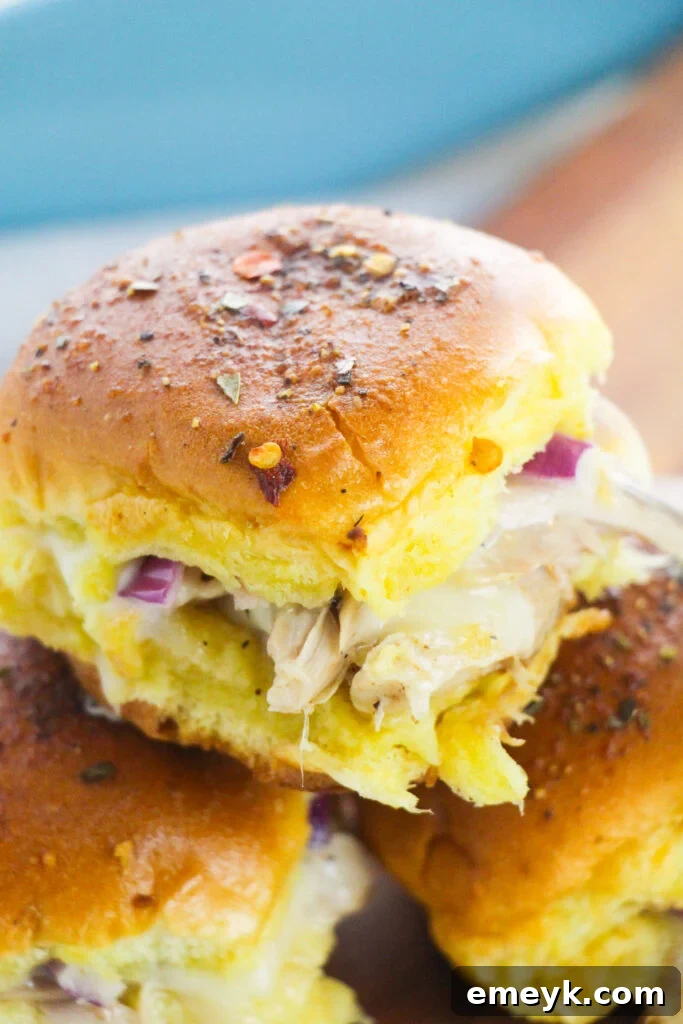 Simple Savory Chicken Sliders 2 Easy Chicken Sliders on a cutting board, garnished and ready to serve