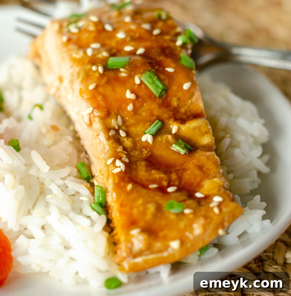 Perfect Glazed Teriyaki Salmon 2 Perfectly baked Teriyaki Salmon on a white plate, garnished with sesame seeds and green onions