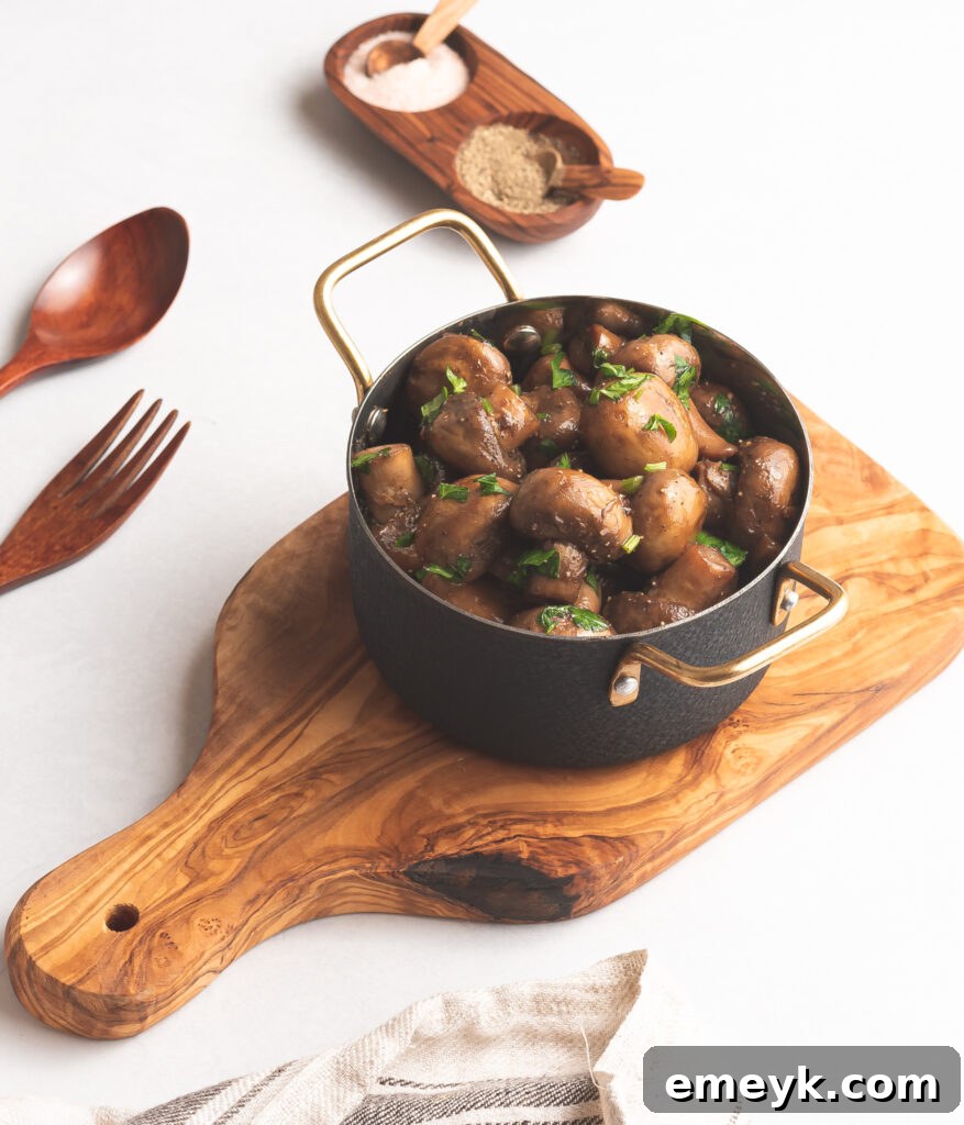 Golden Garlic Mushrooms 4 Perfectly golden brown garlic sautéed mushrooms artfully arranged on a rustic wooden board.