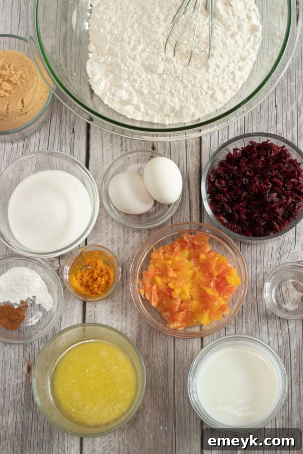 A bowl filled with fresh cranberries, oranges, and other baking ingredients for cranberry bread.