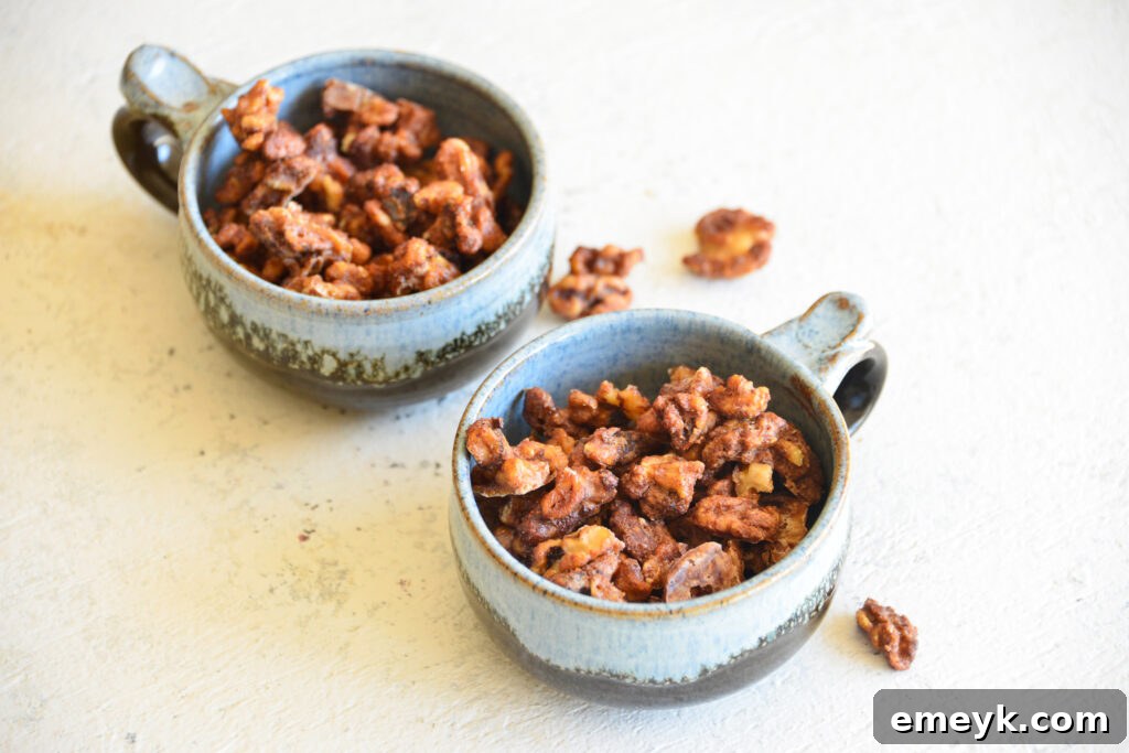 Two small bowls filled with golden, crispy Easy Candied Walnuts, ready to be served as a snack or appetizer.