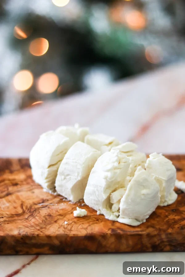 A goat cheese log cut into pieces, ready to be rolled into balls.