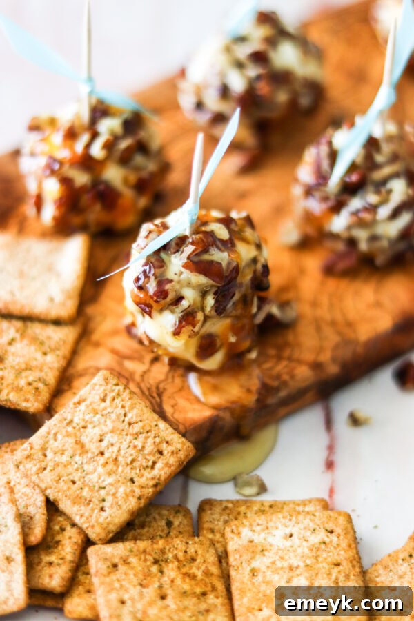 Honey Goat Cheese Balls arranged on a cutting board, garnished with fresh herbs and a honey drizzle.
