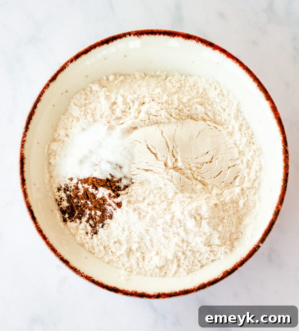 Dry ingredients for Cranberry Bliss Bars, including flour, baking soda, salt, and cinnamon, perfectly mixed in a bowl.