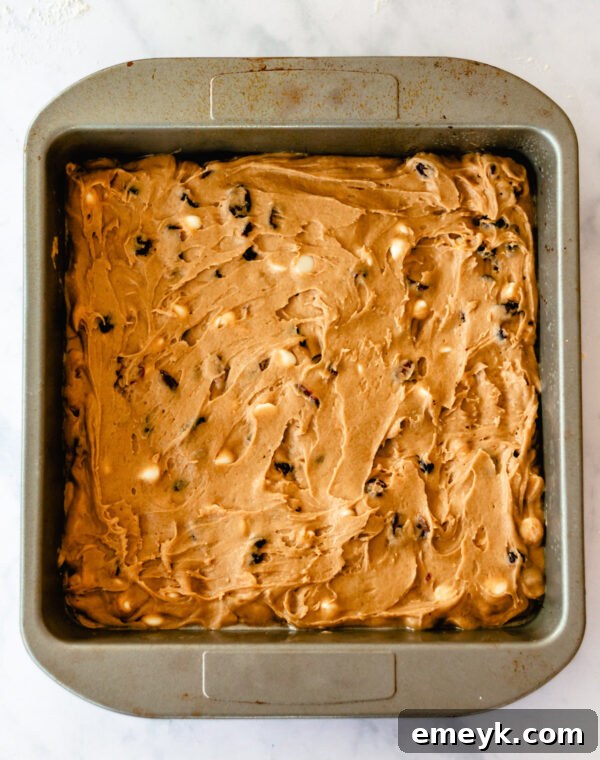 Cranberry Bliss Bar batter spread evenly in a 13x9 inch baking pan, ready for the oven.