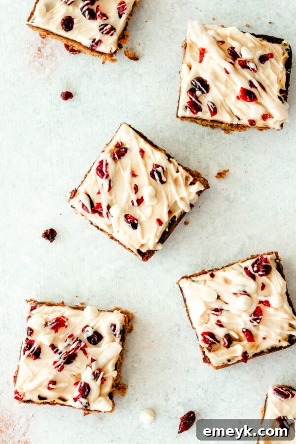 A selection of Cranberry Bliss Bars, cut into triangles and arranged on a white serving board, showcasing their festive appeal.