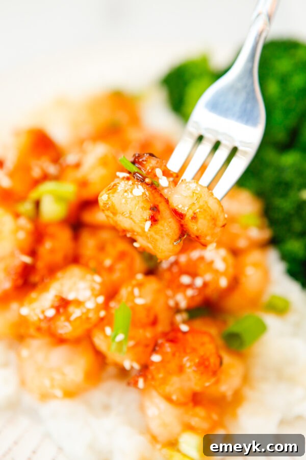 Sticky Sriracha Honey Garlic Shrimp 2 Honey Garlic Sriracha Shrimp served with a fork, garnished with green onions and sesame seeds.