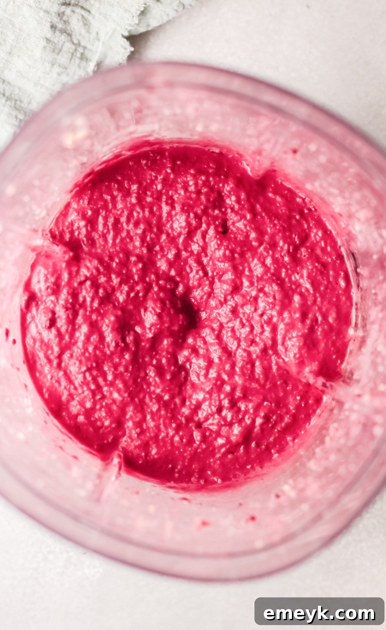 Close-up of freshly blended Easy Beet Hummus in a food processor, showing its smooth texture.
