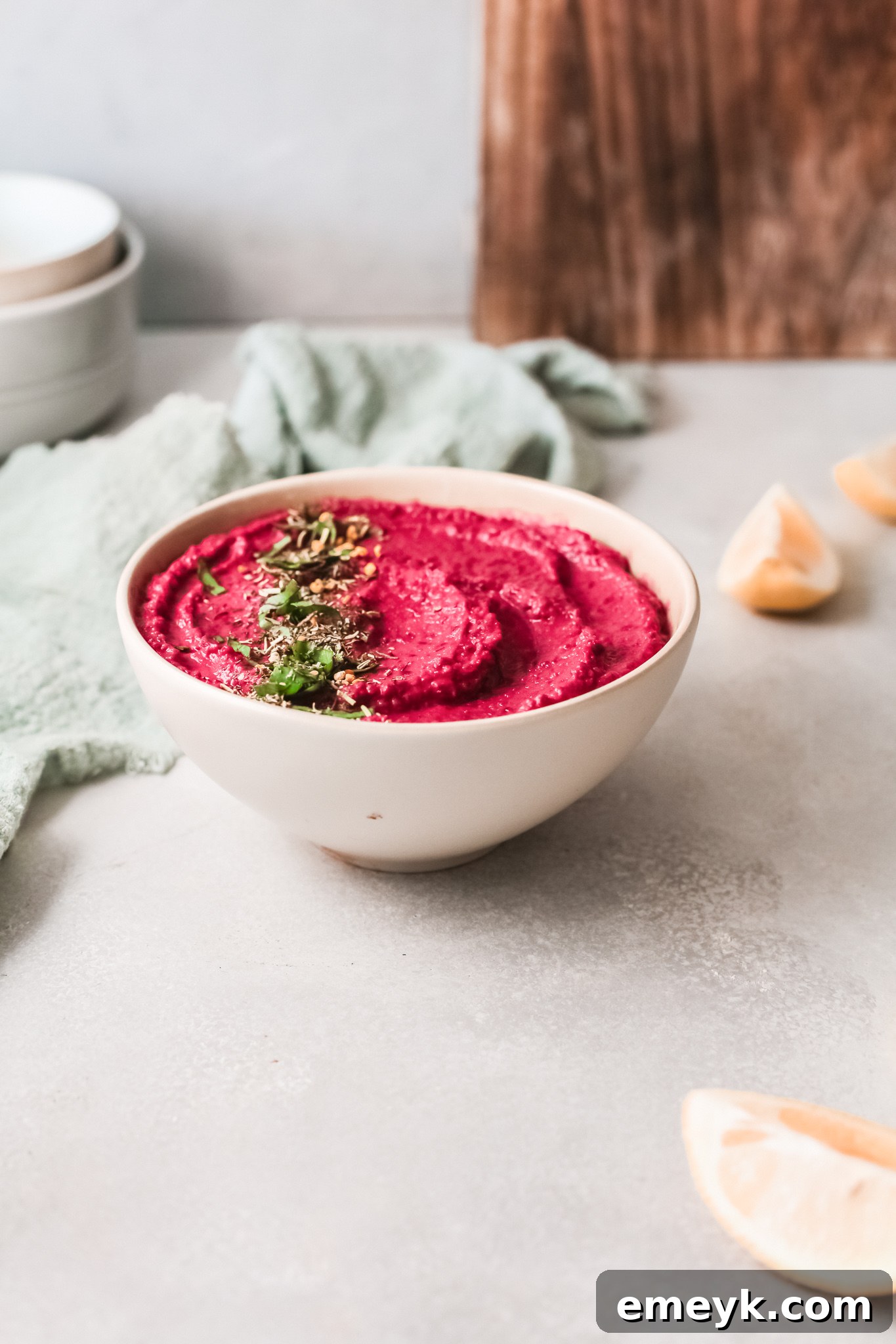 A serving bowl of Easy Beet Hummus, garnished and ready to be enjoyed.