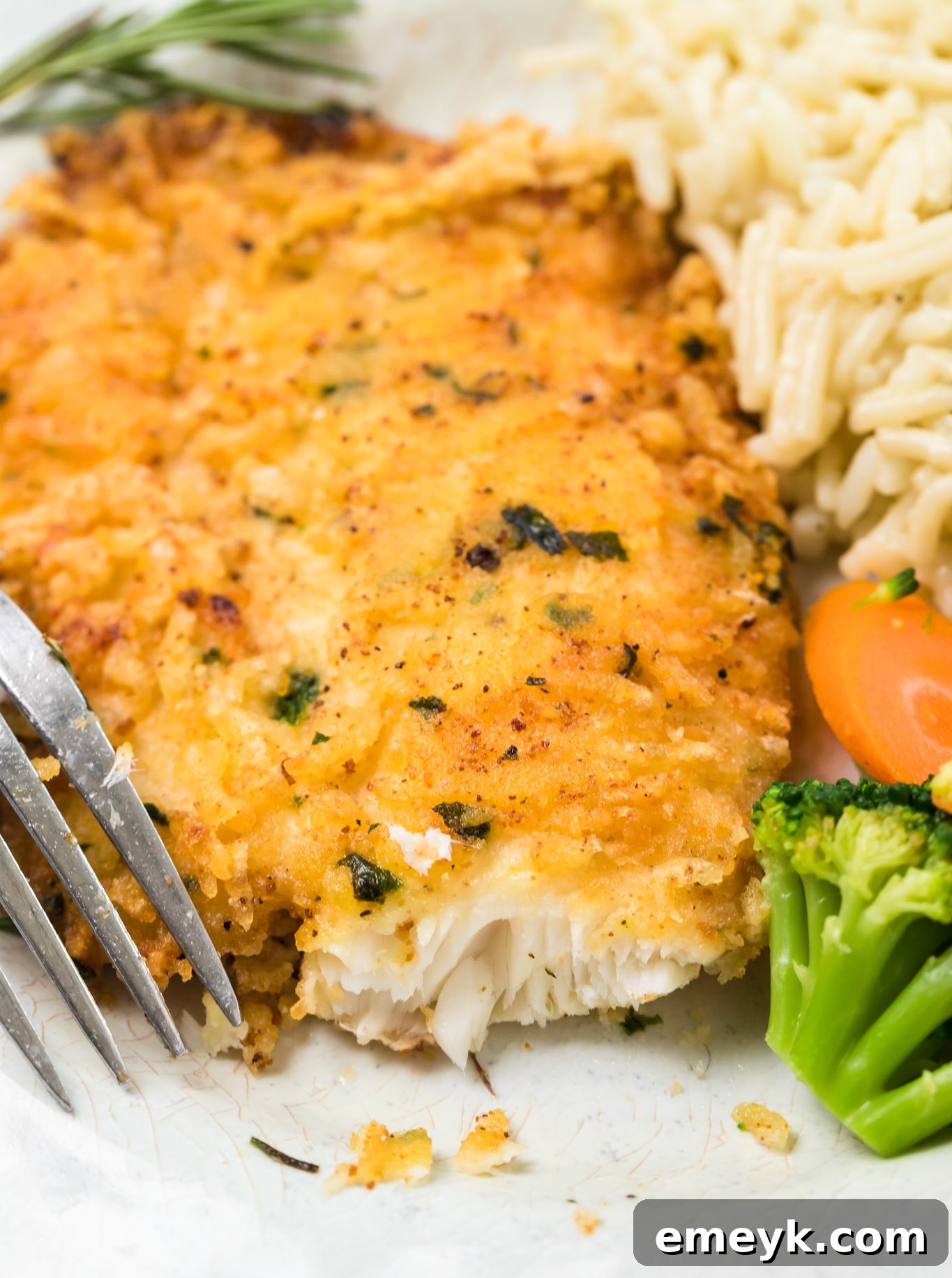 Golden brown Parmesan Crusted Tilapia with a fork, ready to be enjoyed.