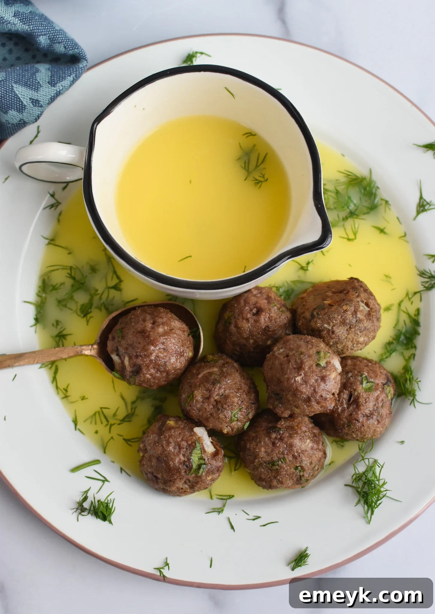 Spiced Lamb Kofta 10 Delicious Lamb Kofta drizzled with a bright and zesty lemon sauce, garnished with fresh herbs, presented on a plate for an inviting meal.