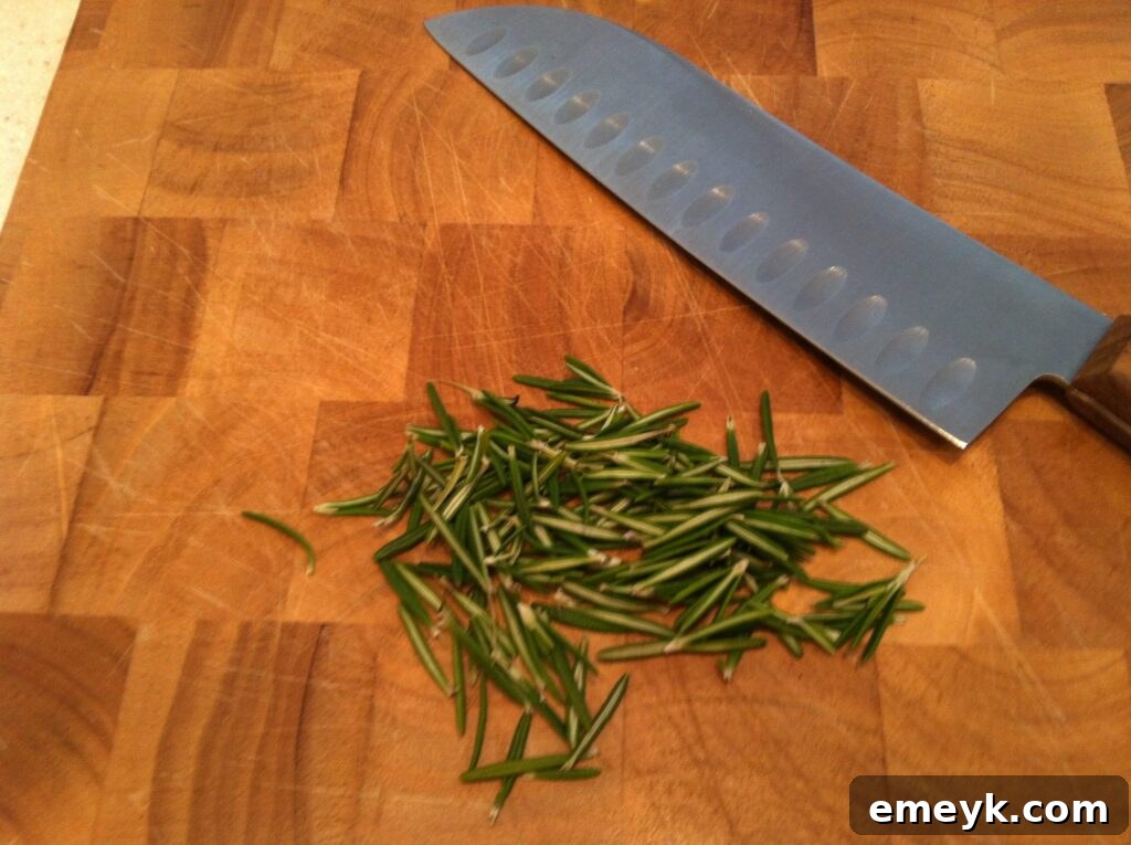 Finely chopped fresh rosemary on a cutting board, ready for the spread.