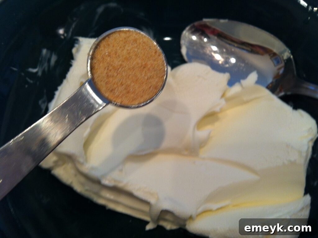 Softened cream cheese with garlic powder sprinkled on top in a white bowl.