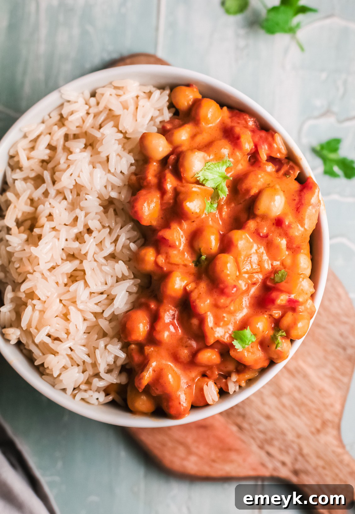 A close-up of finished chickpea curry, garnished with fresh parsley.